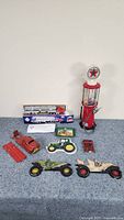 Wide shot of the lot's vintage toys and collectibles including the Texaco gas pump bubble gum dispenser, toy trucks, John Deere tray, and cast iron cars.