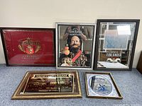 Five framed mirrors arranged on a floor showing different brand advertising reflective surfaces.