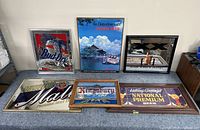 Six beer mirrors and signs displayed on table showing Bud Dry, Crown Beer, Dos Equis, Michelob Malt, Kingsbury, and National Premium brands