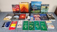 Full view of the 20 travel and geography books laid out on a flat surface, showing a variety of covers including Ancient Egypt, World Atlas of Nations, and various country guides.