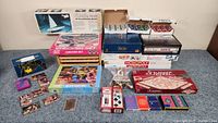 Set of poker chips, boxed board games Monopoly, Scrabble, Trivial Pursuit, puzzles, vintage card decks, and other game components.