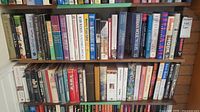 Full shelf view of a collection of fiction books showing varied titles and authors.