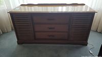 Side view of RCA Victor console stereo closed, showing wood finish and slatted speaker fronts.