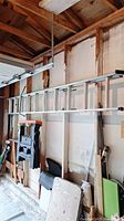 Full view of the 18ft metal extension ladder hung horizontally in garage, showing overall length and structure.
