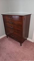 Front view of the wooden highboy dresser showing five drawers with metal handles and polished finish.