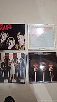 Four LP vinyl album covers shown on floor, featuring The Police, Blondie, Diana Ross and The Supremes, and Elton John.