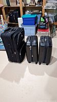 Three black suitcases arranged side by side showing size comparison and exterior condition