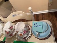 Four tea cups and saucers displayed with floral and colorful patterns.