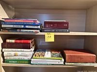 Books arranged on two shelves, mix of hardcover and softcover.