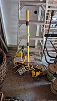 Full view of the yellow and black halogen work light on its adjustable stand with power cord coiled on the floor.