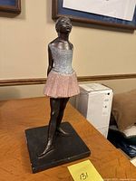 Front angled view of ballerina statue showing silver bodice and pink skirt on square base, minor knicks visible