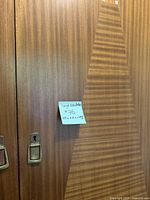 Close-up of wood veneer surface showing texture and vintage metal handles with note of wardrobe dimensions.