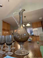 Photo of the smoky glass decanter showing its shape, handle, bulbous body, and stopper