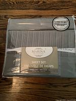Front view of sealed package showing Marina Decoration label and 6-piece sheet set in gray color with striped pattern on fitted sheet.