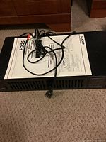 Nikko EQ 25 graphic equalizer unit with power cord and RCA cables on top, placed on carpeted floor.