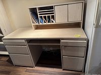 Full view of the office desk with hutch, drawers, and keyboard tray showing the compartments and storage spaces on a wood laminate finish.