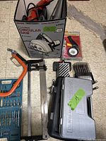 Sears Craftsman circular saw in box alongside clamps, cable tie dispenser, and wood spade bit set