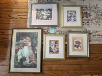 Five framed art prints of children, flowers, and animals displayed on a floor rug showing variety in size and frame style.