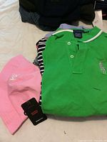 Photo of green Ralph Lauren Golf polo shirt and pink Levis bucket hat with brand tag