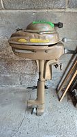 Photo of vintage metal outboard motor showing overall condition, body, pull start, and propeller detail.