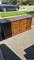Full view of vintage Zenith stereo console cabinet with wooden finish and brass hardware in sunlight outdoors.