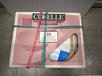 Box packaging view showing Corelle branding, 21-piece set labeling, and partial view of dishware inside box.