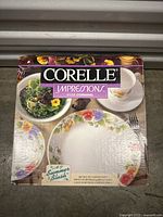 Box showing Corelle Impressions Summer Blush 20-piece dinnerware set box with floral plate design