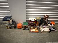 Wide-angle view showing all items in the lot, including boxed NutriBullet, Panasonic rice cooker, ceramic teapot, stacks of wooden containers, and various boxed kitchen items.