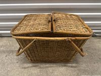 Side view showing the dual handles and woven wicker material on the basket exterior.