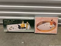 Two vintage vanity trays; one boxed Ultra Vue Deluxe Vanity Tray by Danielle with display items, one round mirrored tray with gold edge and small pump bottles