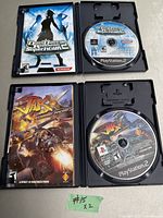 Two PlayStation 2 games visible: Dance Dance Revolution SuperNOVA 2 and Jak X: Combat Racing, both open showing discs and covers, with Jak X manual included.