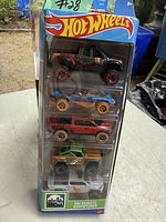 Photo of 5 Hot Wheels vehicles in original blister pack packaging, showing all cars vertically stacked inside.