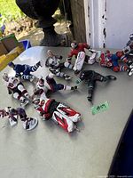 Hockey figures arranged on a table outdoors, showing various poses and team uniforms including a goalie in full gear.