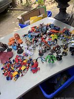 Overview of various kids' toys spread on table showing superheroes, action figures, mini squishies and more