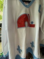 Front side of white CCM hockey jersey with Quebec Nordiques logo and fleur-de-lis accents