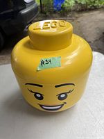 Yellow LEGO storage head container with smiling face, showing overall condition and size.