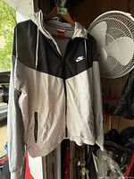 Front view of men's Nike jacket showing color-block design and logo