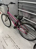 Side view of the full pink Raleigh Sundown bicycle showing frame, tires, pedals, seat, and handlebar.