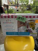 Front of sealed box showing Tylina Sweetshop Decorating Airbrush Kit with colorful cupcake and flower graphics.