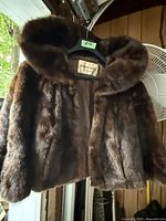 Front view of vintage mink jacket, showing dark brown fur, collar, and interior satin lining tag showing Robertson Furs brand