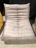 Front view of the light brown fabric lounge chair with tufted cushions and button details on seat and backrest.