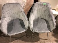 Front view of two grey fabric chairs showing fabric texture and metal legs