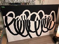 Full view of abstract black and white canvas with looping thick brush strokes creating an abstract design