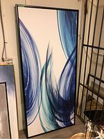 Full view of large rectangular framed canvas print with abstract blue brushstrokes.