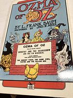 Front cover of the book Ozma of Oz by L. Frank Baum with colorful illustrated characters from the story