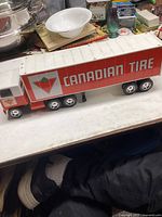 Photo showing full side view of large Canadian Tire transport truck toy on a white surface, displaying logo and color scheme.