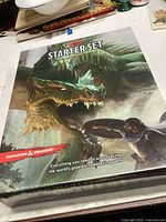 Photo of sealed Dungeons & Dragons Starter Set box showing the cover art with dragon and hero.