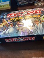 Full view of Monopoly Star Wars Saga Edition game box with cover art showing main Star Wars characters.