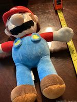 Front view of the plush Mario doll showing the full body length and colors