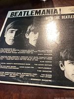 Front cover of vinyl record sleeve showing Beatlemania! title and image of The Beatles members' faces.